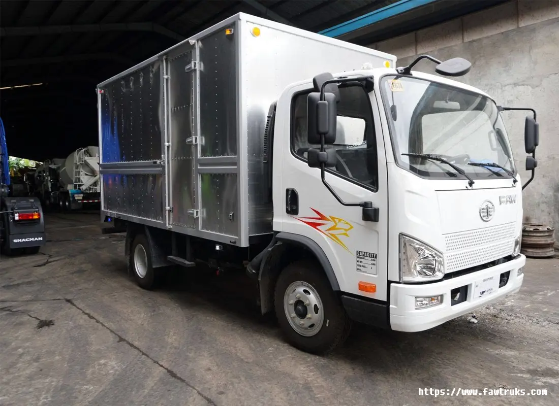 Camión FAW de caja seca blanca para reparto urbano en México, vista lateral delantera en patio industrial