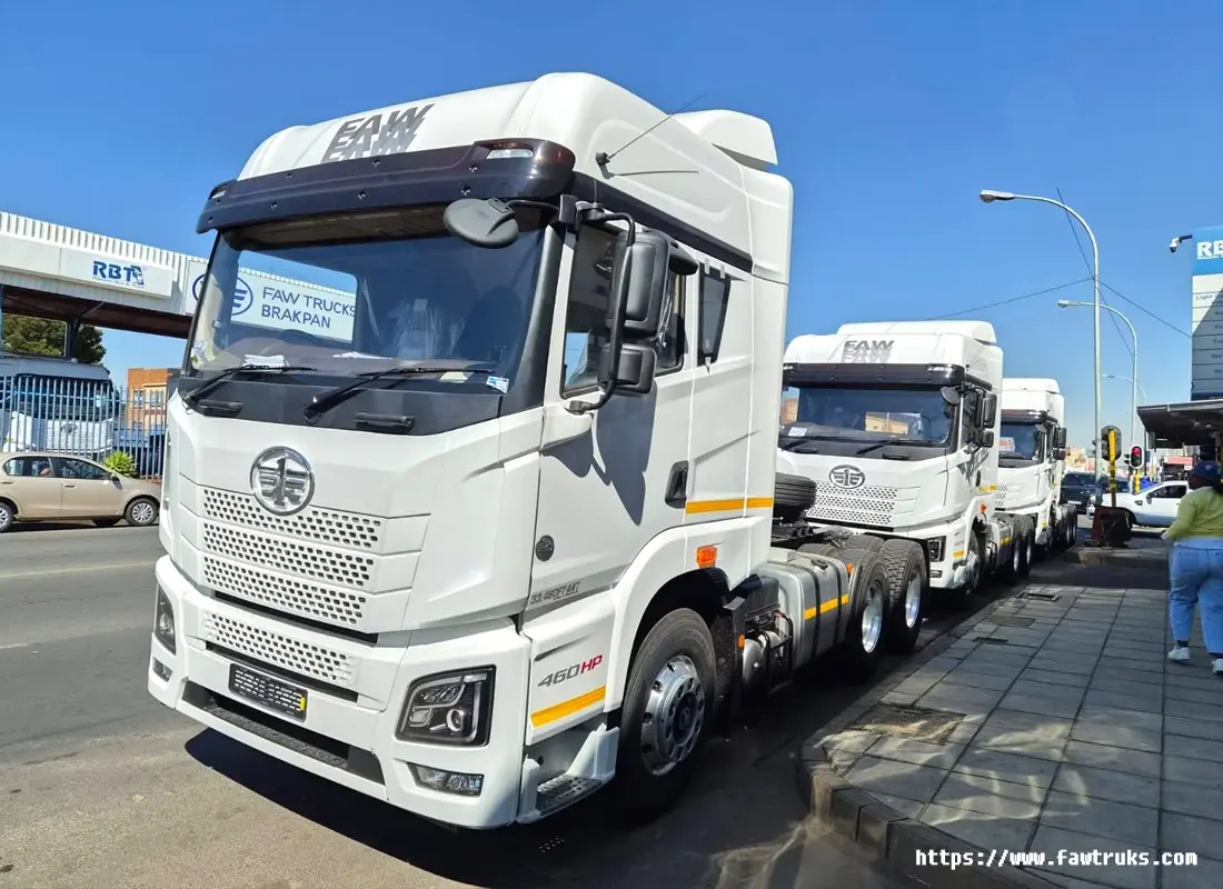 Tractocamión FAW JH6 460HP blanco en 45 grados frente a concesionario, configuración 6×4 con quinta rueda