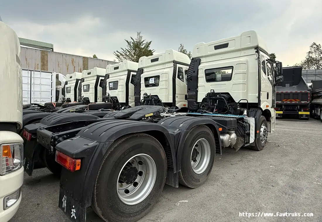 Flota de tractocamiones FAW blancos con quinta rueda y configuración 6×4, estacionados en patio industrial en Ecuador